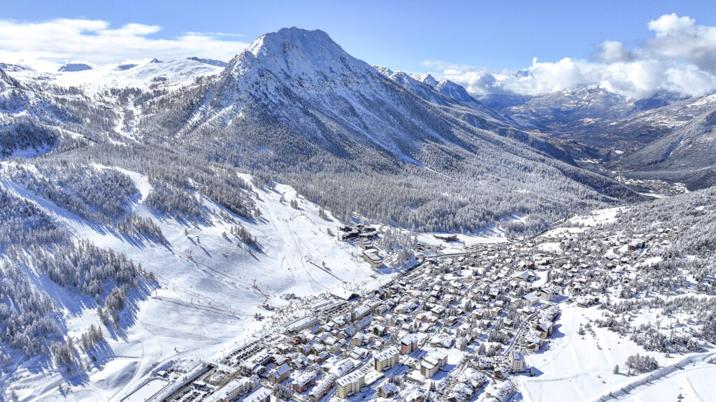 Vue aérienne enneigée de la station de Montgenèvre et du village — location de chalets et pistes de ski