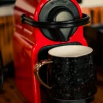 Machine Nespresso rouge en train de remplir une tasse de café chaud