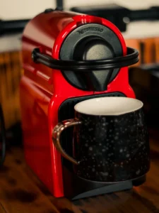 Machine Nespresso rouge en train de remplir une tasse de café chaud
