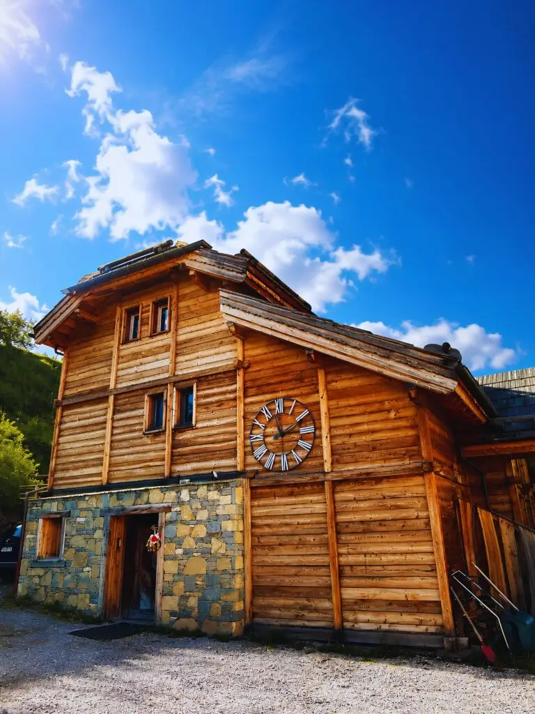 Façade principale en bois et pierres du Chalet D à Vars, avec ses grandes terrasses et baies vitrées de standing