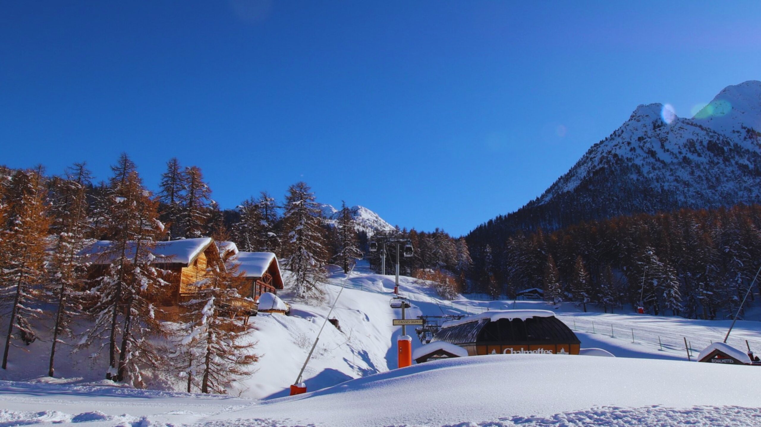 Vue enneigée sur la piste de ski et la gare du télémix des Chalmettes depuis le chalet La Clautre à Montgenèvre.